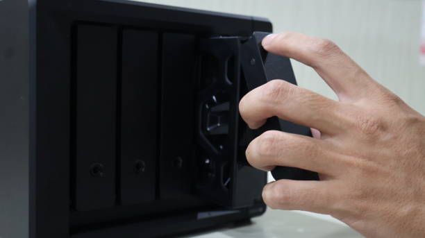 hand inserting a hard disk into a NAS